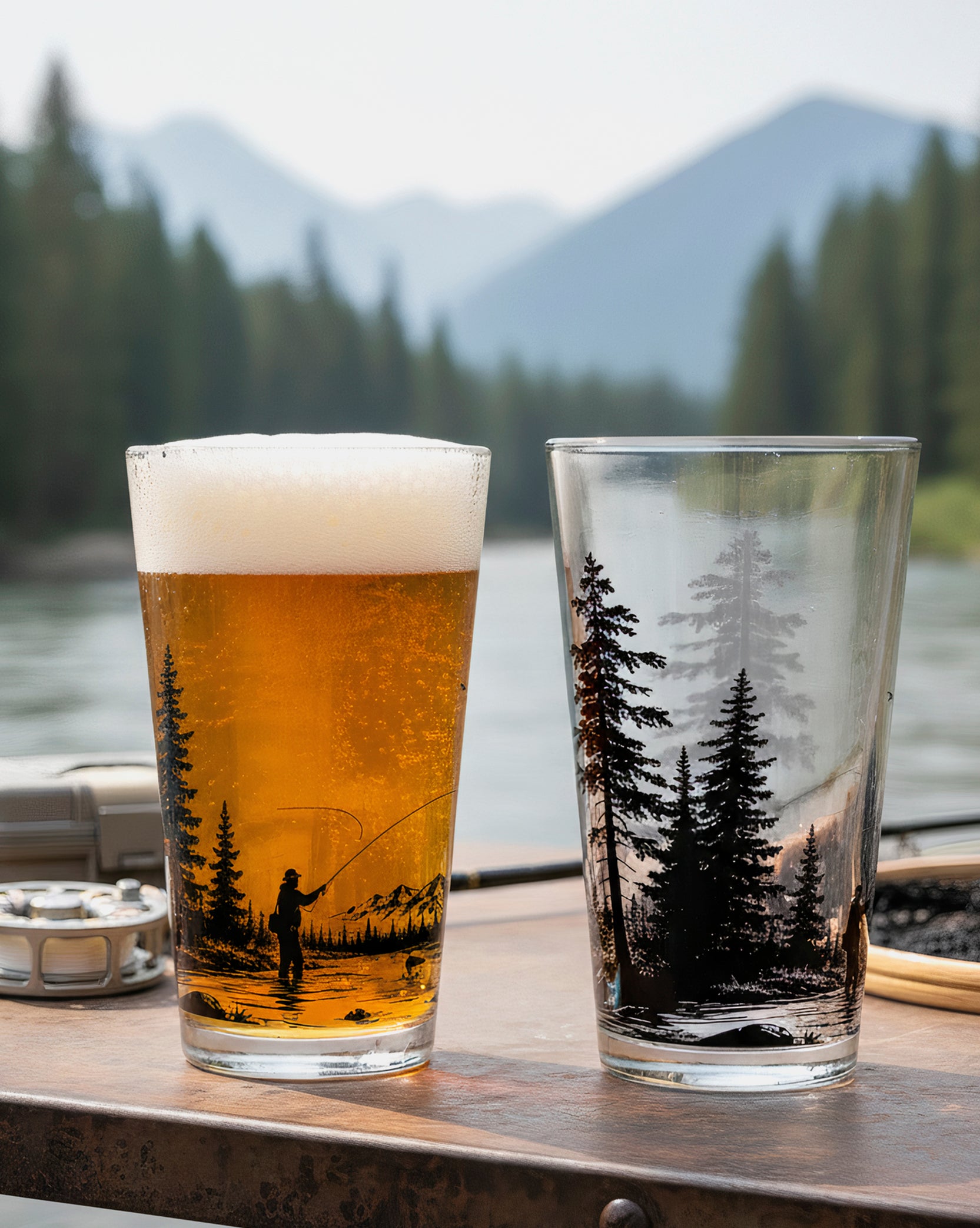 Two glasses with tree and fishing design on a wooden surface with a scenic background