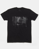 A black short-sleeve crewneck t-shirt featuring a distressed, high-contrast graphic print of a deer in a forest on the front, displayed flat against a light gray background.