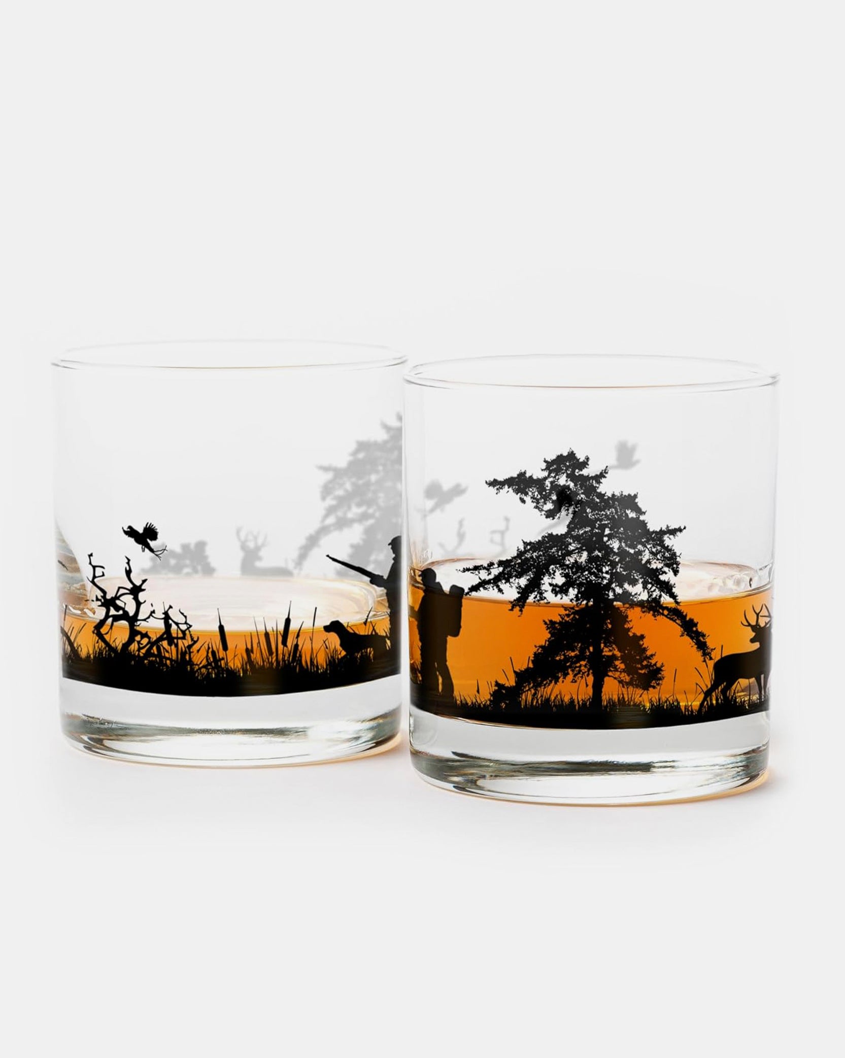 Two glass tumblers with hunting scene design on a white background